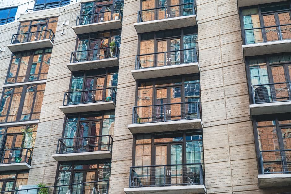Contemporary apartment building exterior with concrete facade and glass balconies.