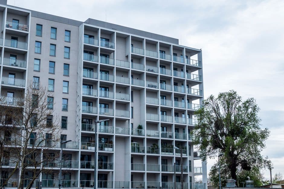 Contemporary multistory apartment building with balconies and large windows.